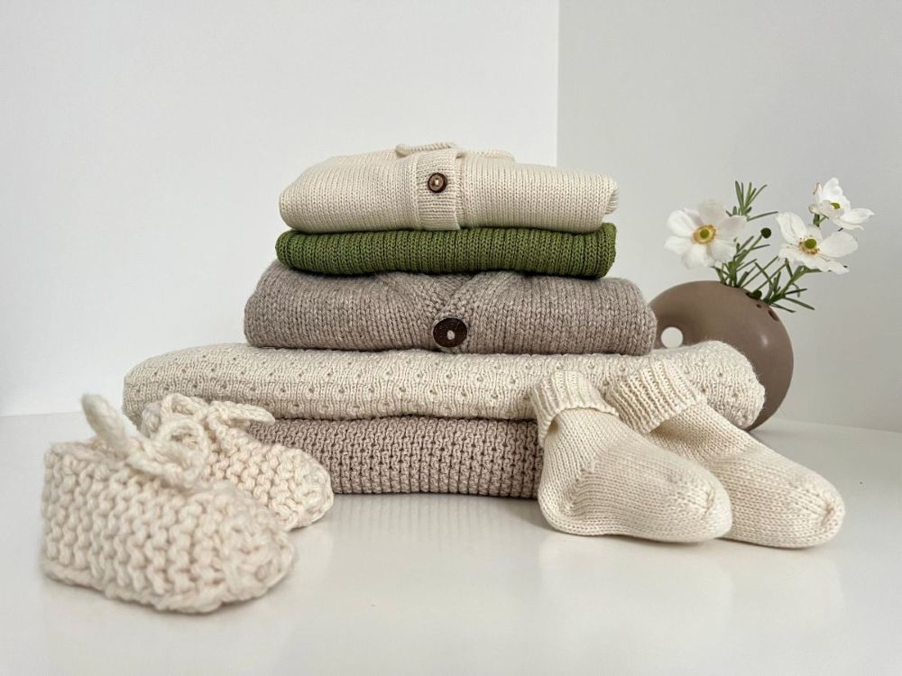 A collection of hand knitted baby merino clothing and gifts
