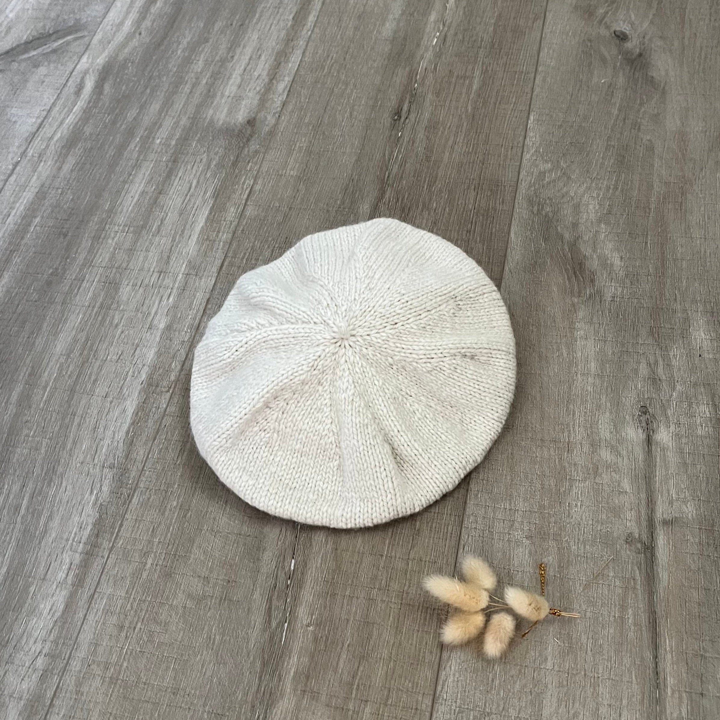 natural beret on a wooden floor with a small plant