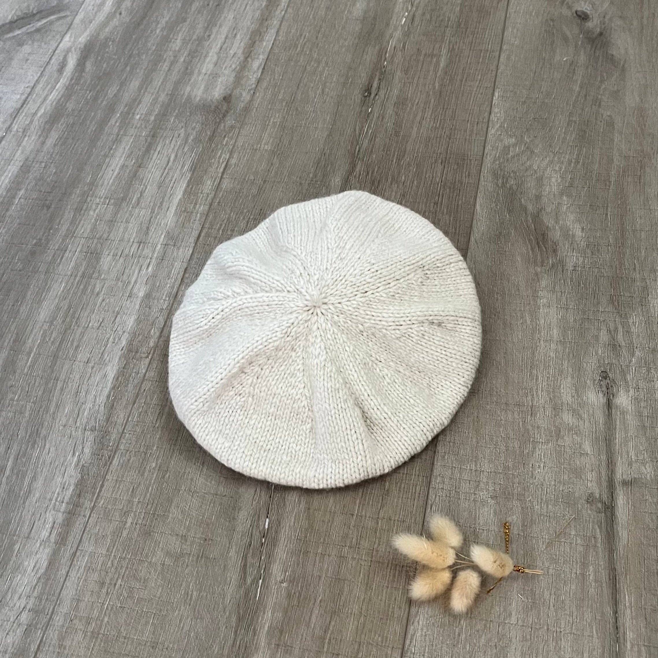 natural beret on a wooden floor with a small plant