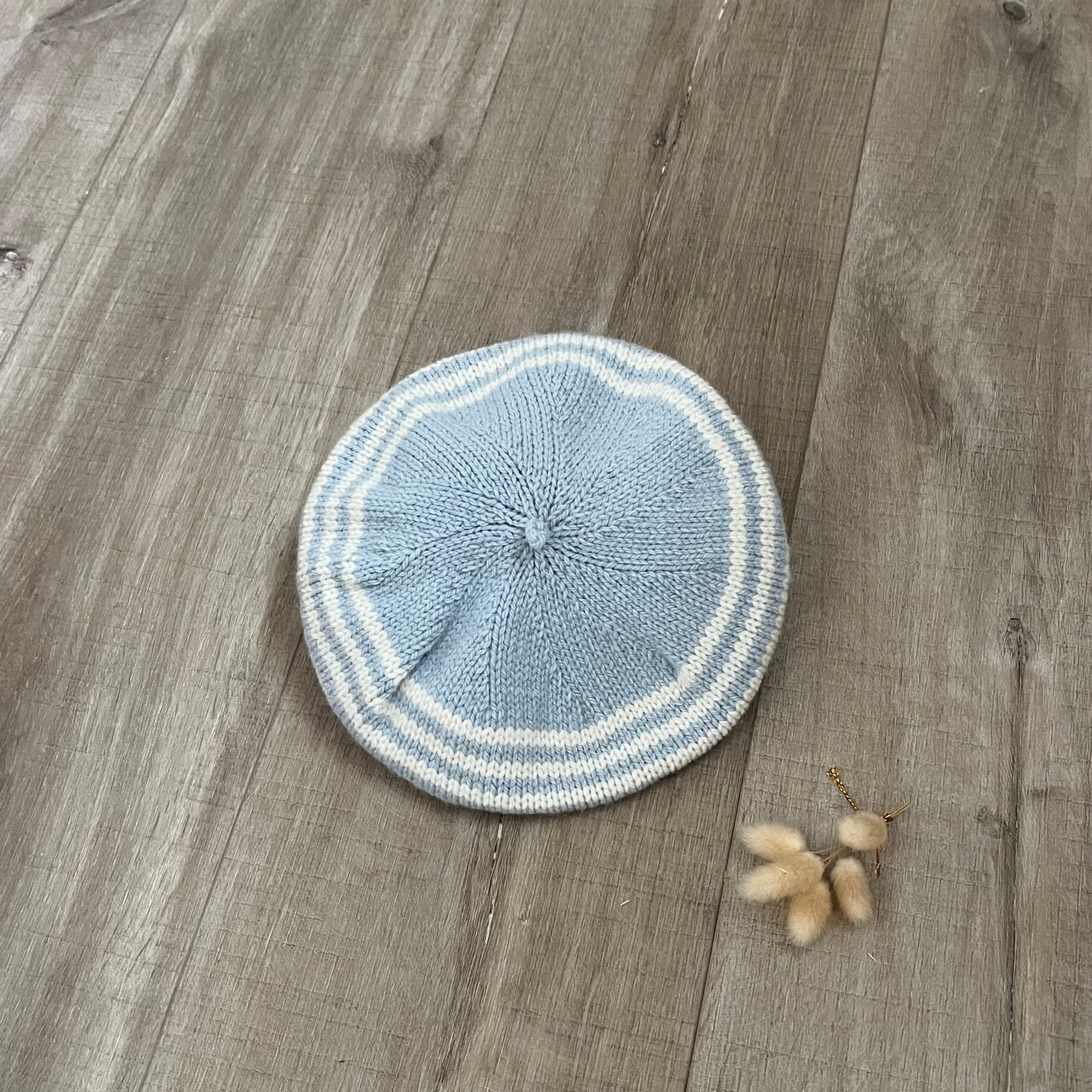 Knitted blue and white beret on a wooden floor