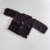 Chocolate knitted baby cardigan on a light grey background
