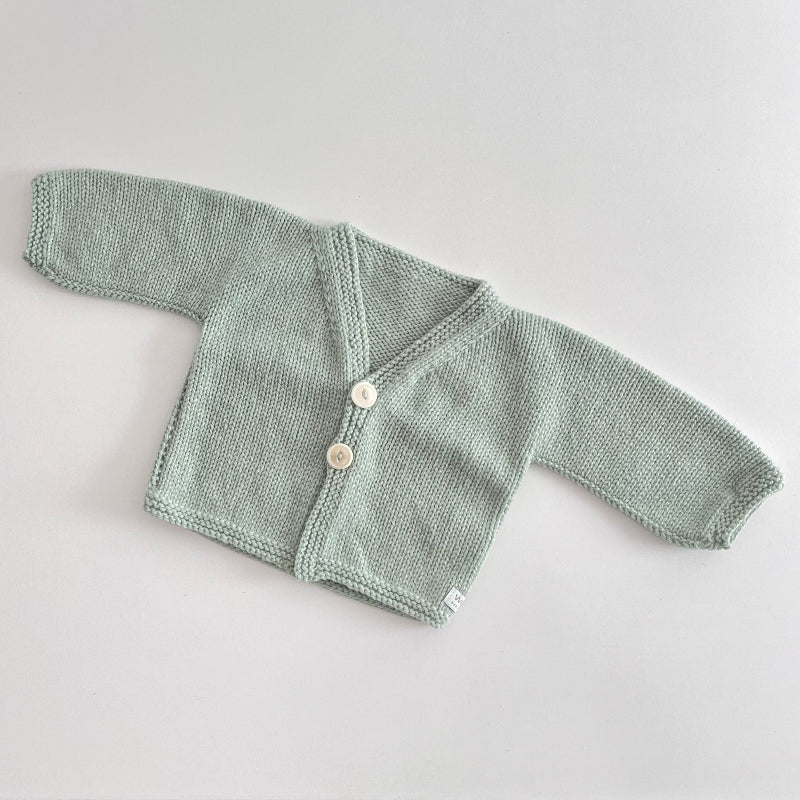 Mint knitted baby cardigan on a light grey background