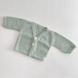 Mint knitted baby cardigan on a light grey background