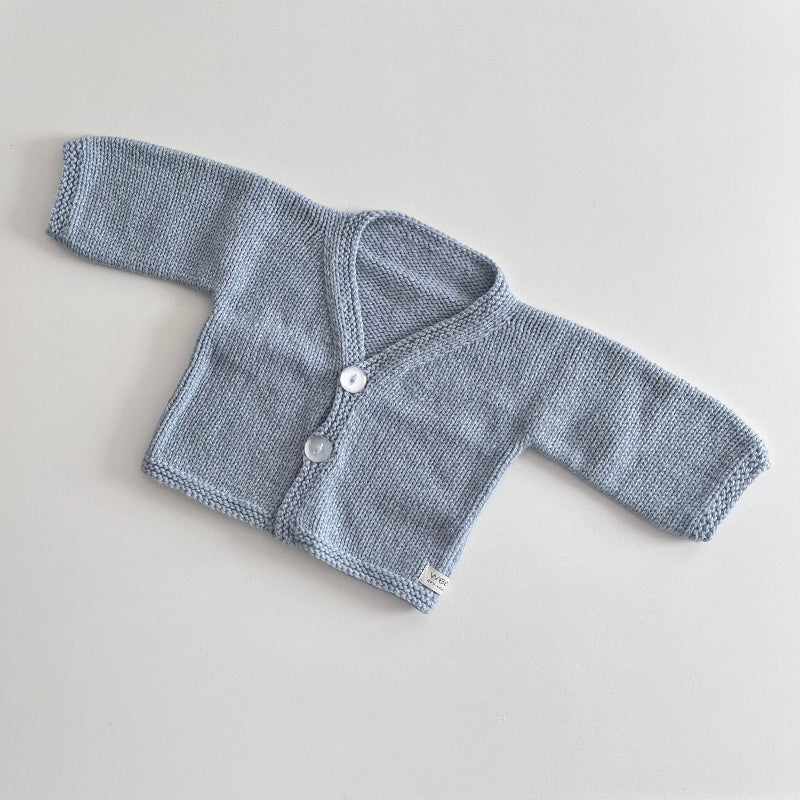Powder blue knitted baby cardigan on a light grey background