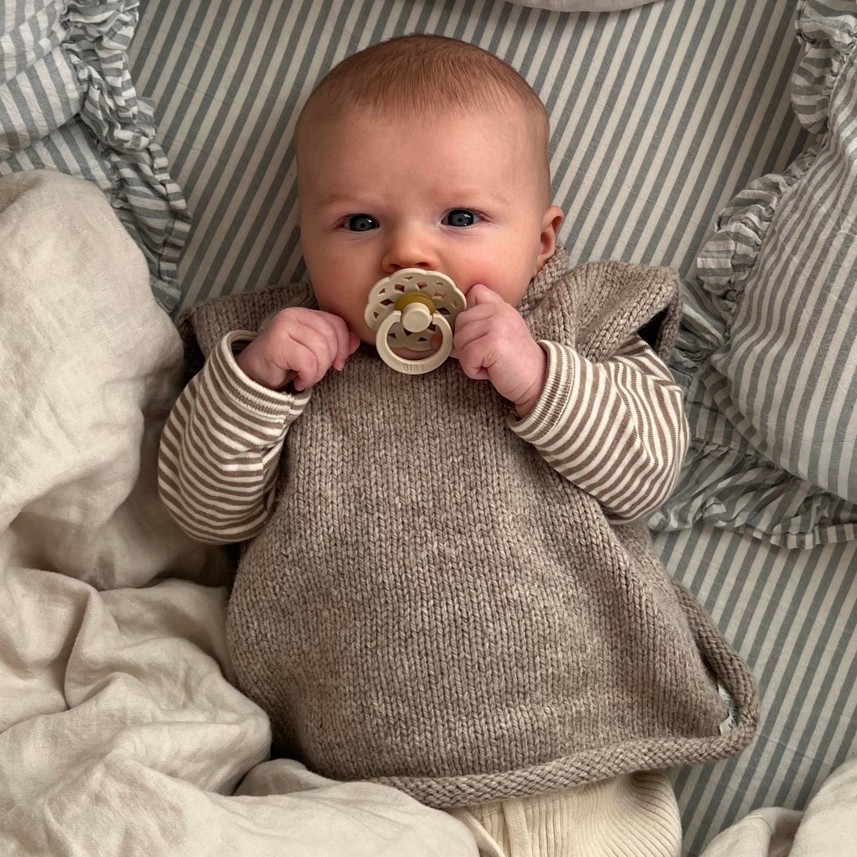 Baby girl wearing oatmeal roll neck vest