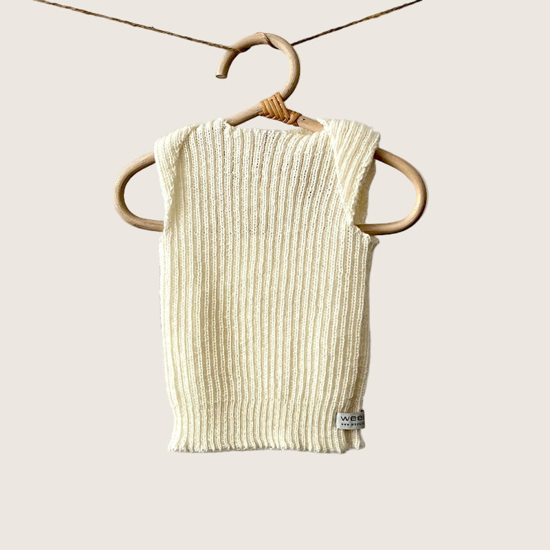 Ivory ribbed baby singlet hanging on a wooden hanger against a plain background