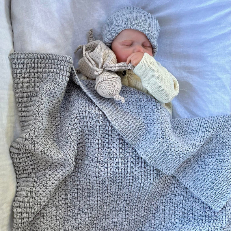 Baby sleeping in misty blue bassinet blanket