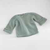 Mint knitted baby slouchy sweater on a white background