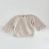 Natural knitted baby slouchy sweater on a white background