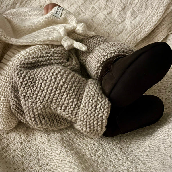 Baby wearing chunky knit pants and lambskin chocolate booties