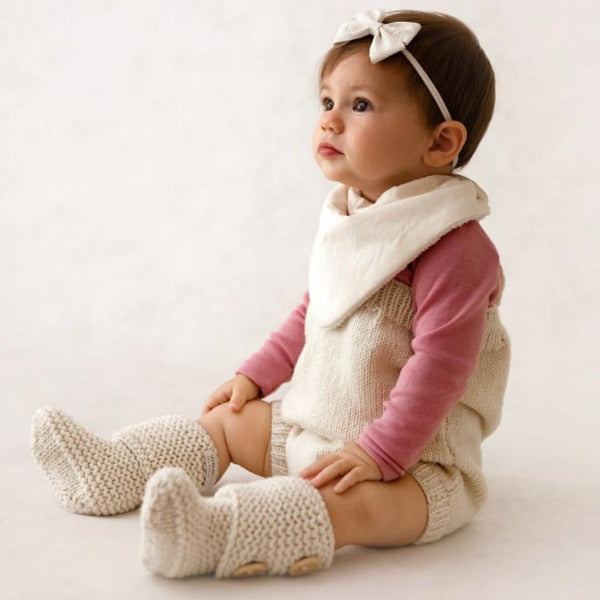 Baby wearing natural rompers and chunky knit boots