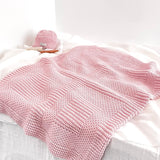 Blossom pink baby pram blanket on shelf with baby hair brush and matching pink beanie