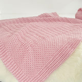 Blossom pink merino bassinet blanket on sheepskin rug