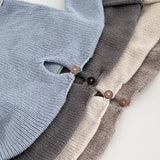 Stack of sweaters in blue, grey, and beige with wooden buttons.