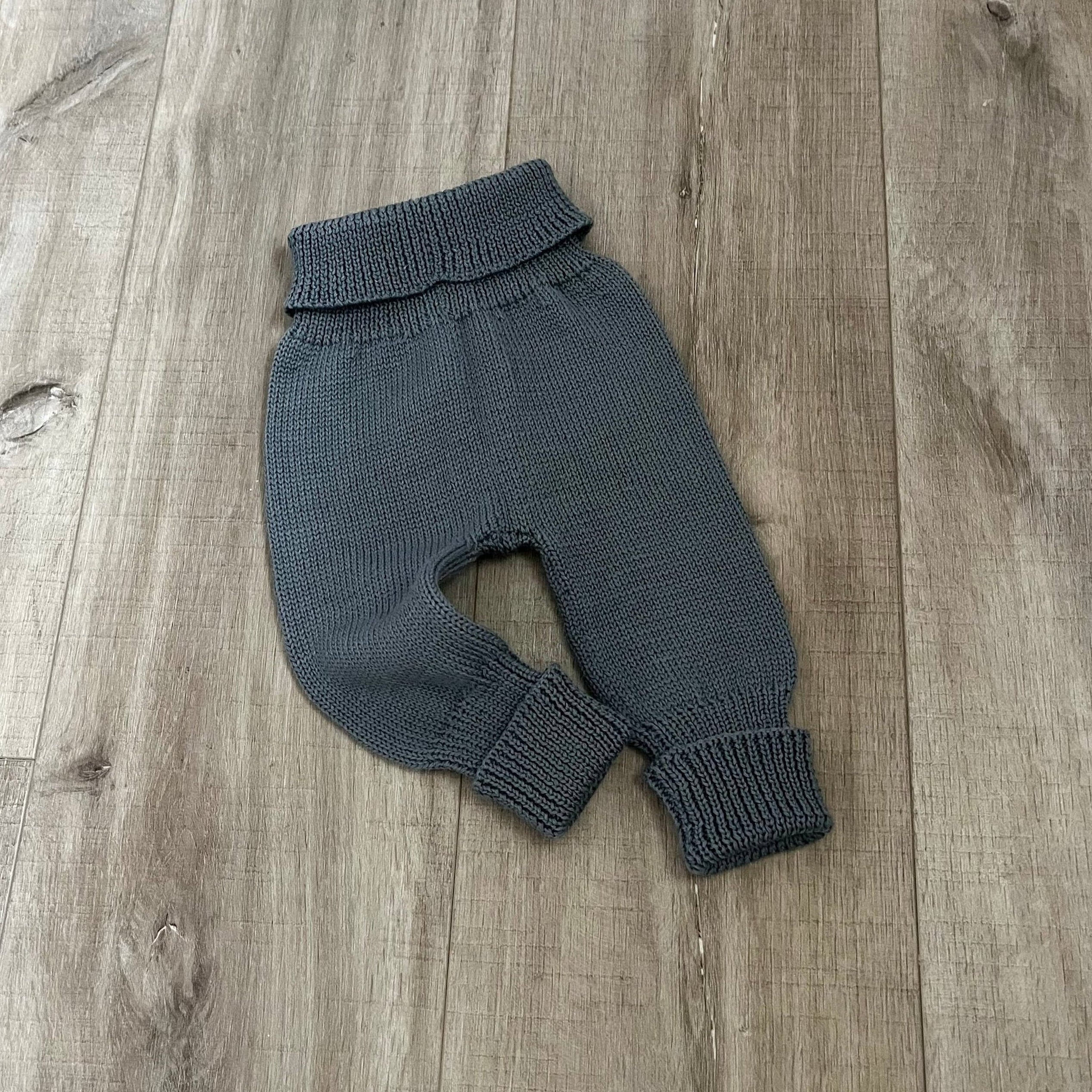 Baby dusky blue colour knitted jodhpurs on wooden surface