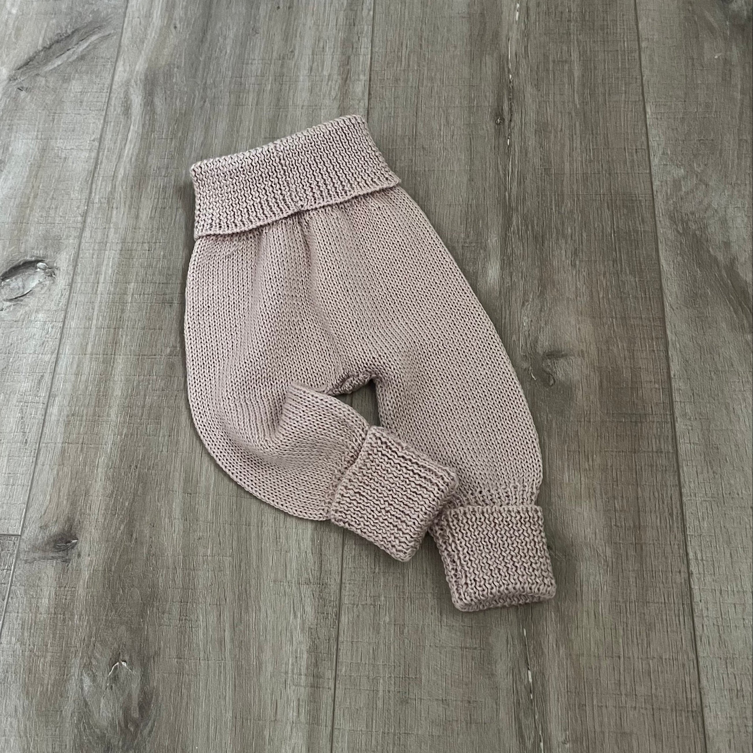 Baby sandstone knitted jodhpurs on wooden surface