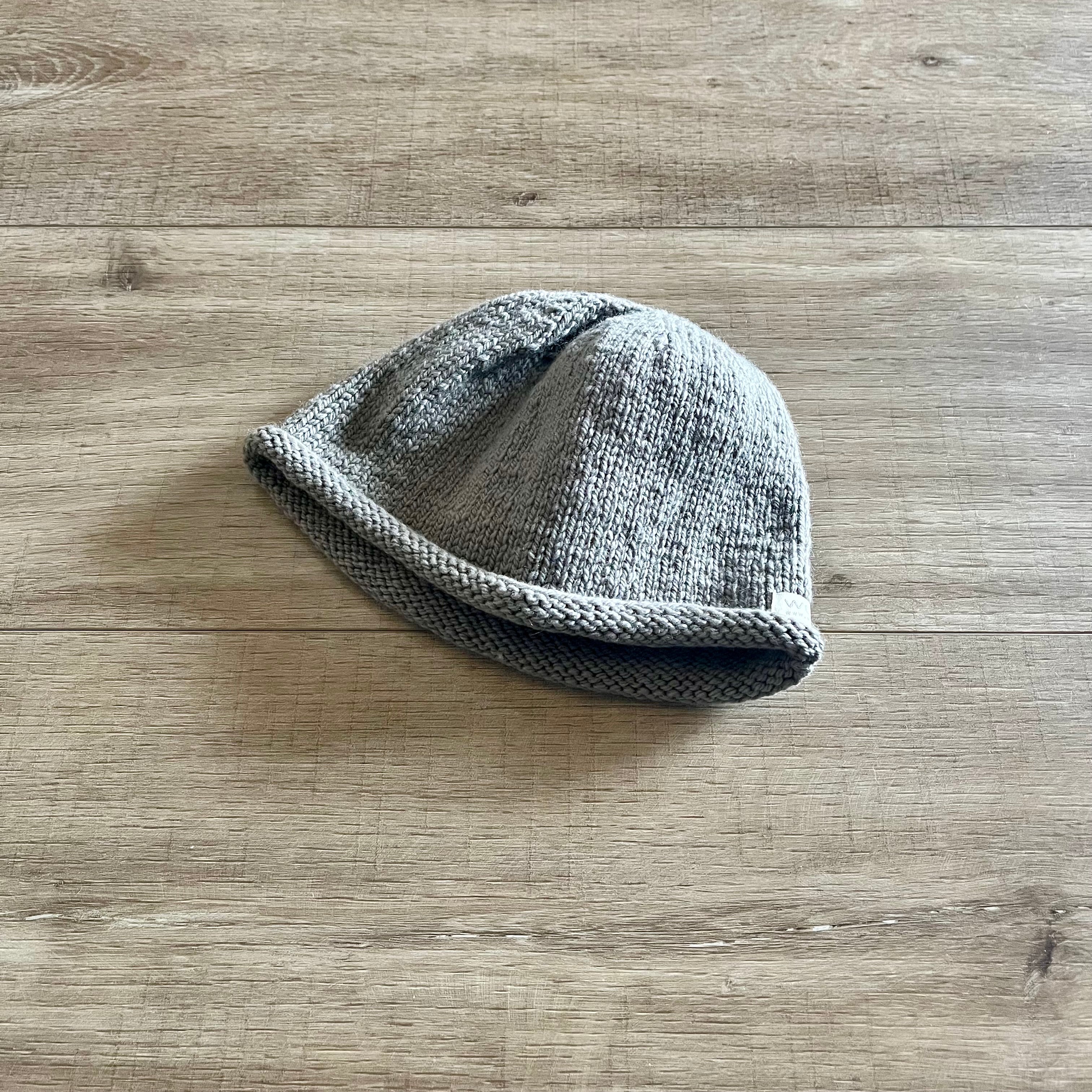 Knitted baby hat on a wooden surface