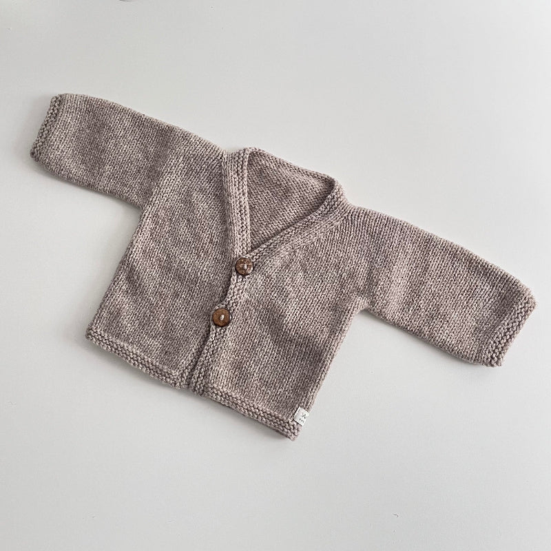 Knitted oatmeal marle baby cardigan with buttons on a light grey background
