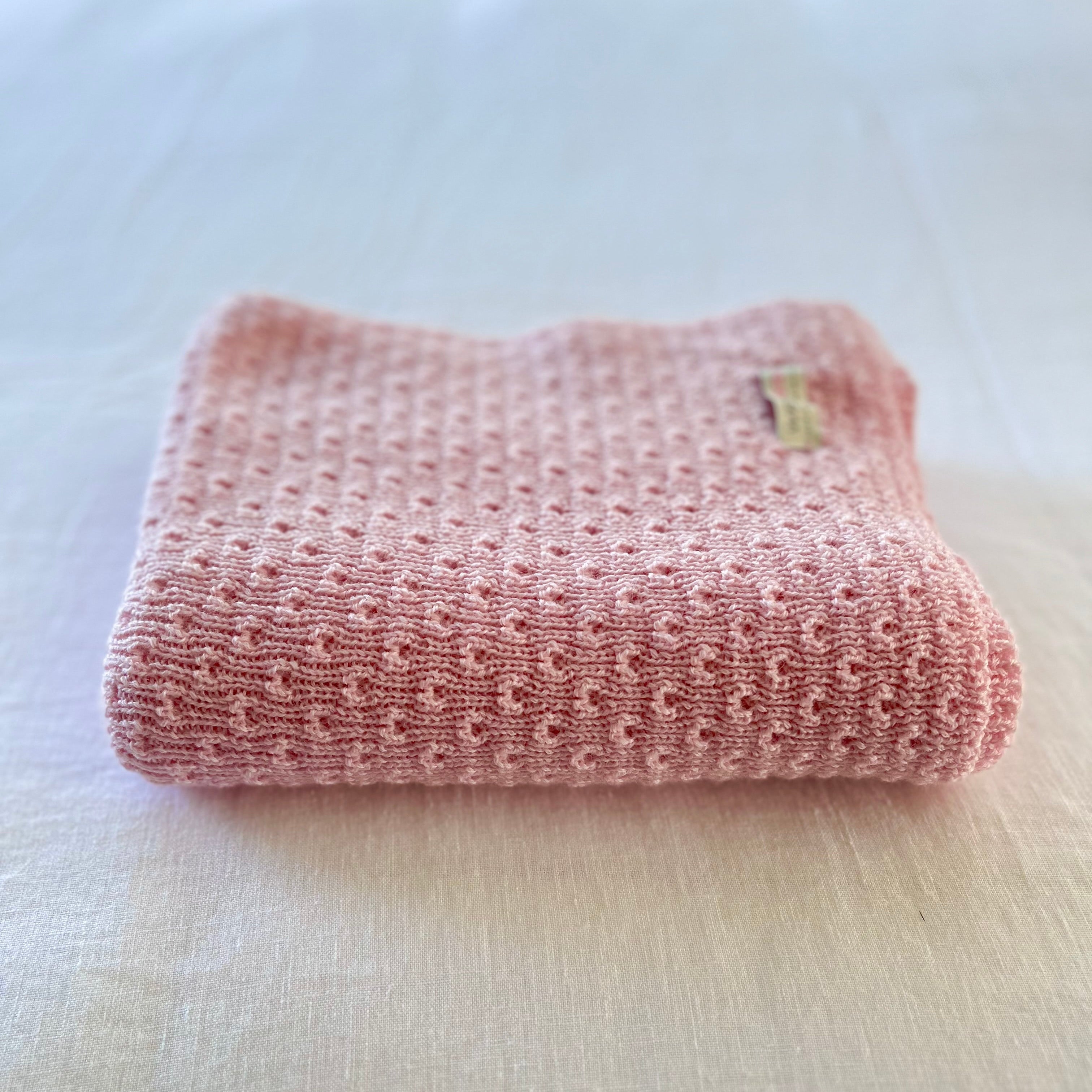 Pink textured baby wrap on a light-colored surface