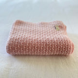 Blossom pink merino baby wrap on cotton sheet