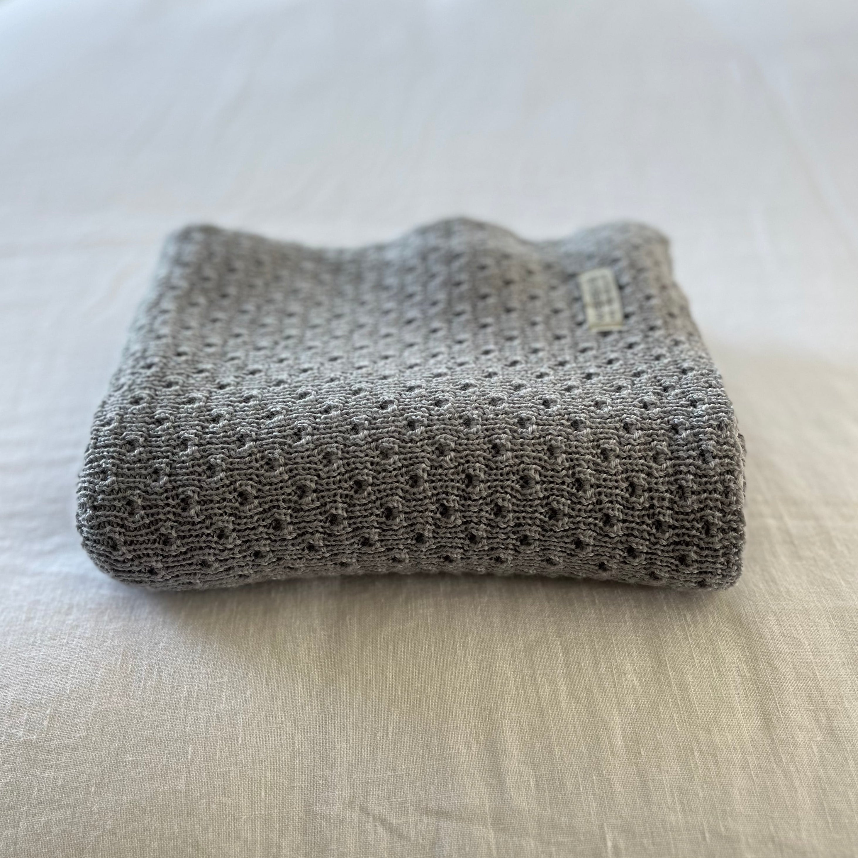 Misty blue textured baby wrap on a light-colored surface