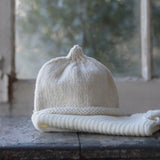 Natural baby beanie and vest on table