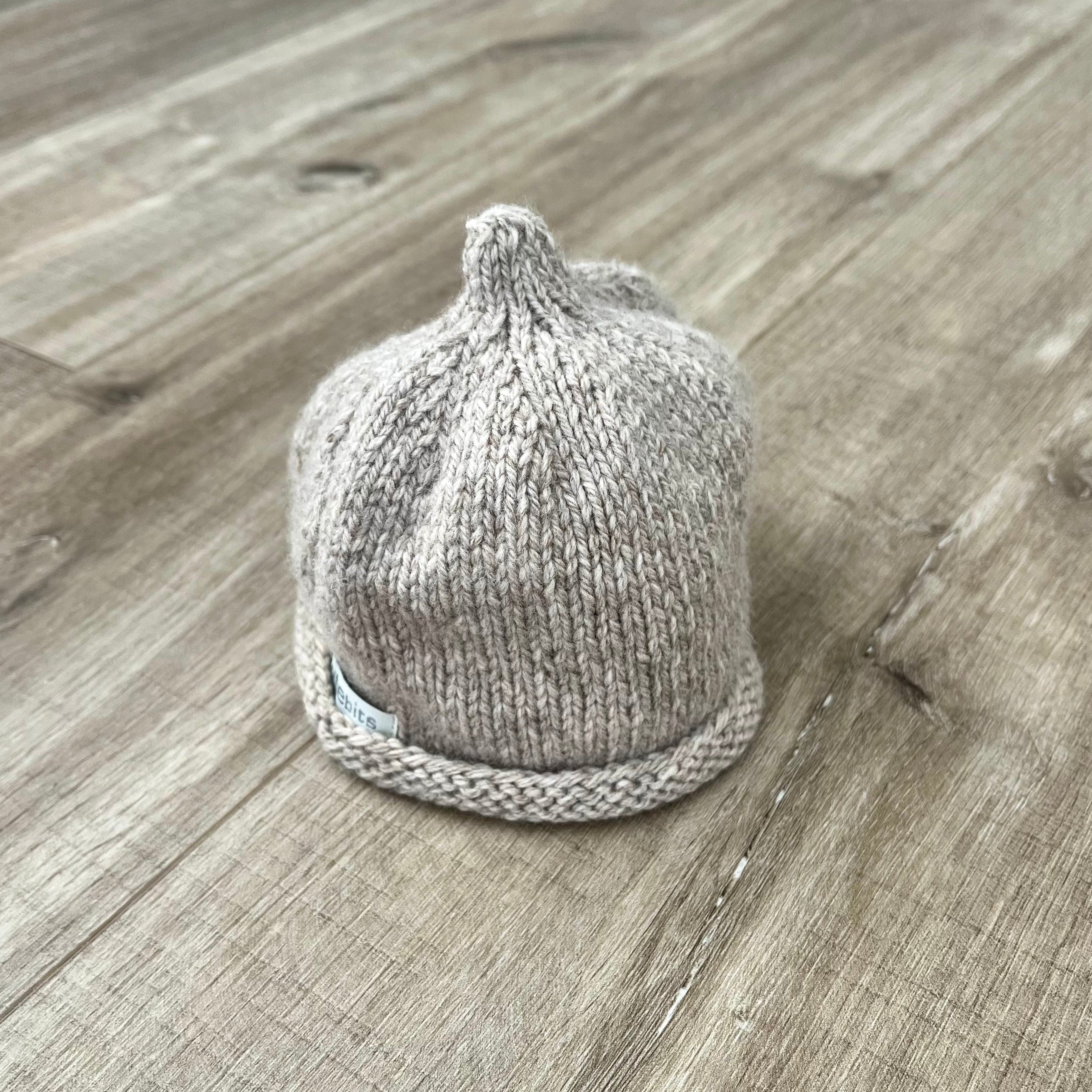Baby-pixie-point-beanie-oatmeal-colour-on-wooden-surface