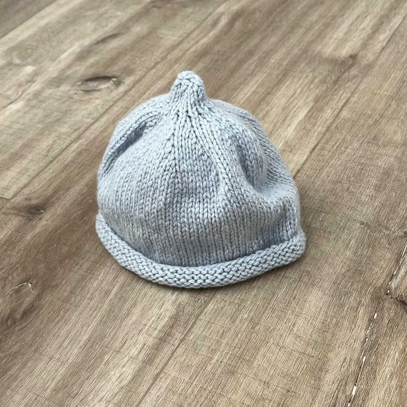 Baby-pixie-point-beanie-powder-blue-colour-on-wooden-surface