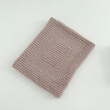 Knitted sandstone pram blanket on a light gray background