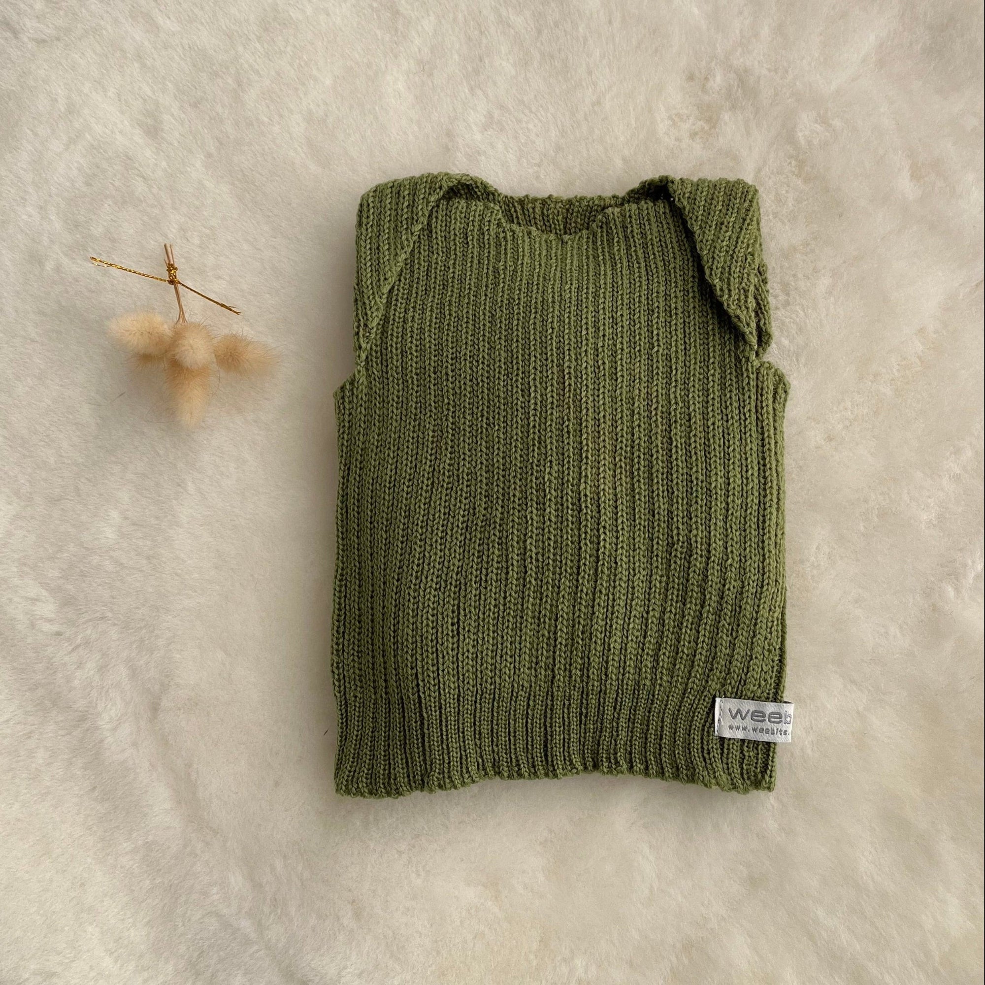 Moss premature baby vest on sheepskin rug