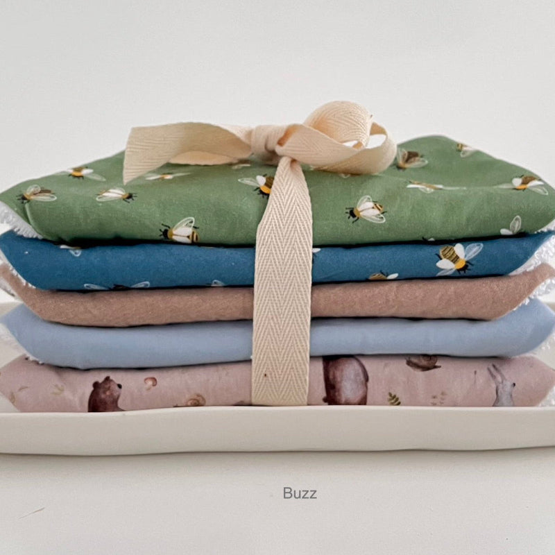 Stack of folded dribble bibs with a ribbon on a white background