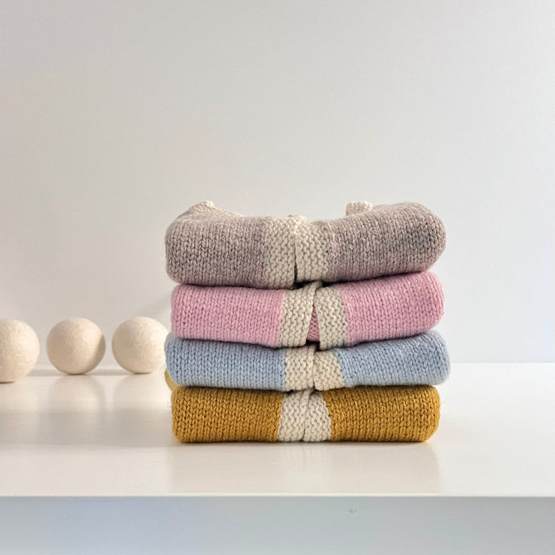Stack of Chloe cardigans on white bench
