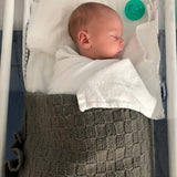 Baby asleep in mushroom travel rug beanie and booties