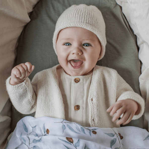 Baby wearing natural cardigan and beanie