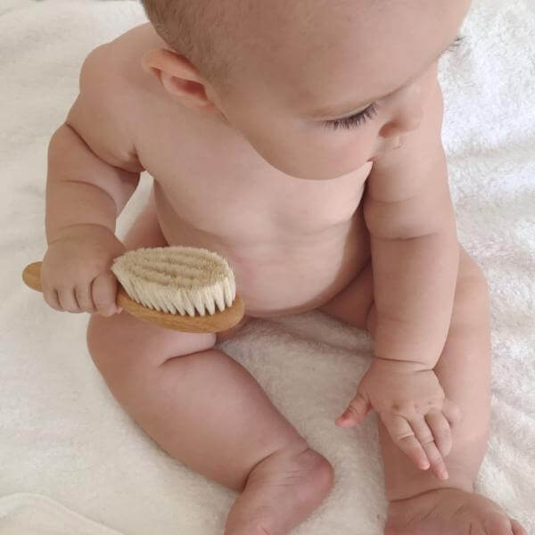 Child with baby newborn hairbrush