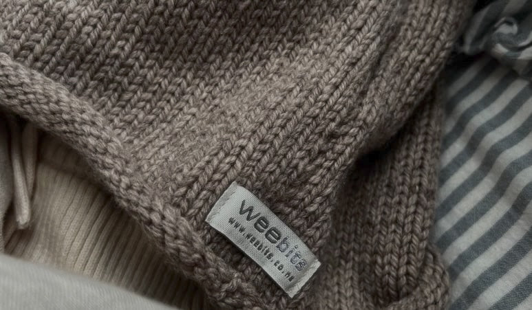 Close-up of a soft knitted baby merino roll-neck vest with Weebits logo tag