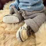 Baby wearing cream crochet booties