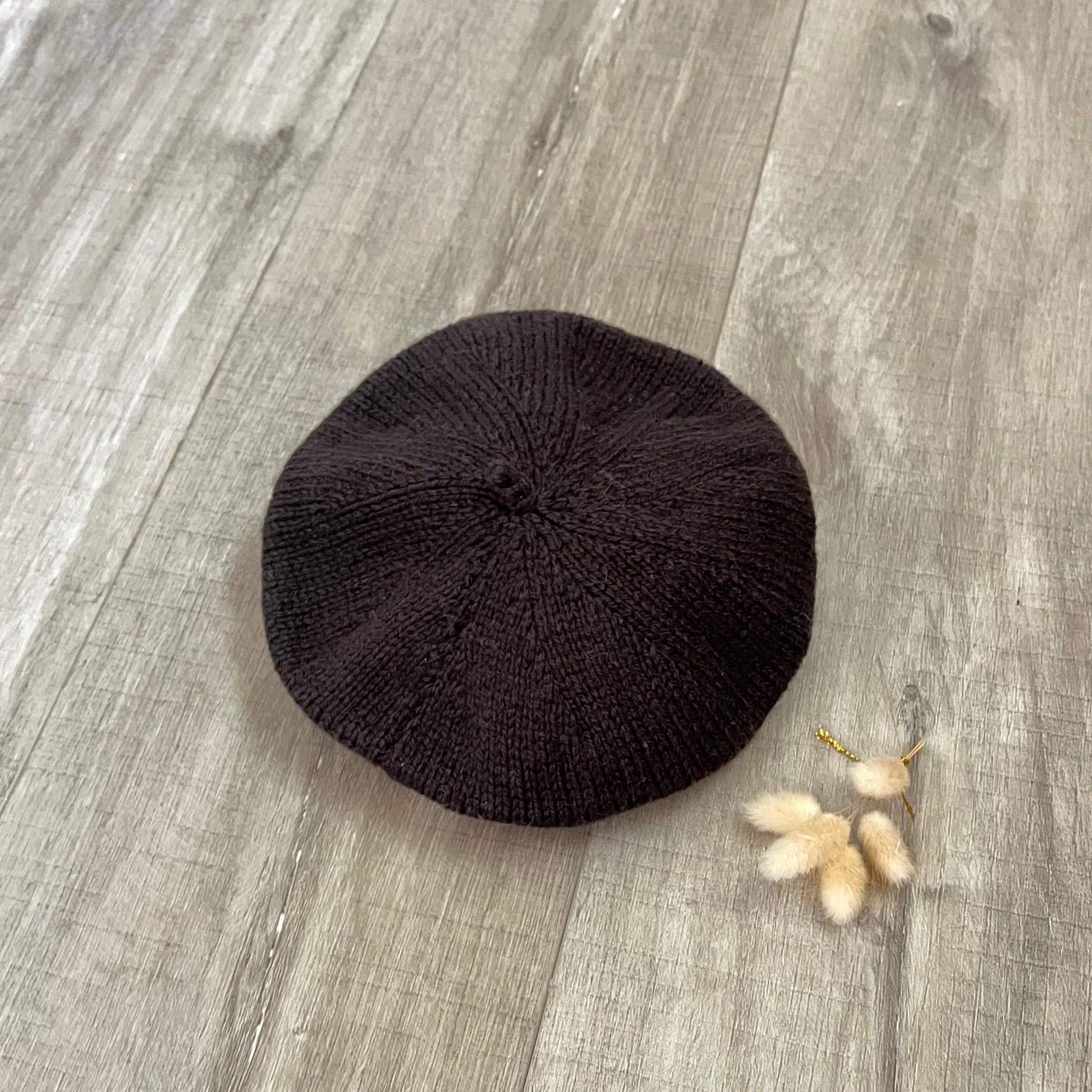 chocolate beret on a wooden surface with dried flowers.