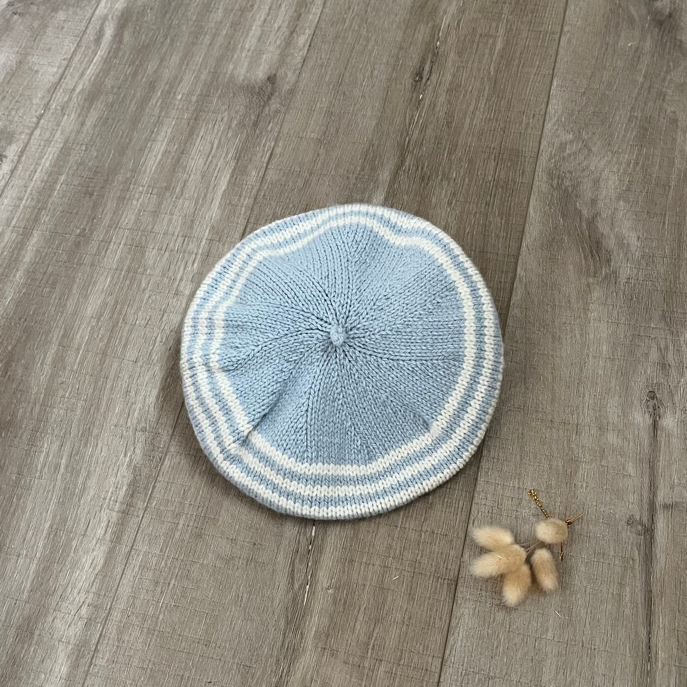 Knitted blue and white beret on a wooden floor