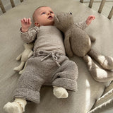 baby in cot wearing chunky knit pants