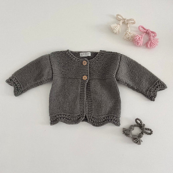 Mushroom coloured knitted baby cardigan on a light grey background