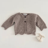 Oatmeal marle coloured knitted baby cardigan on a light grey background