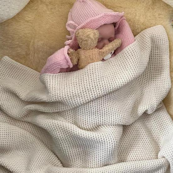 Baby sleeping in a merino buggy blanket