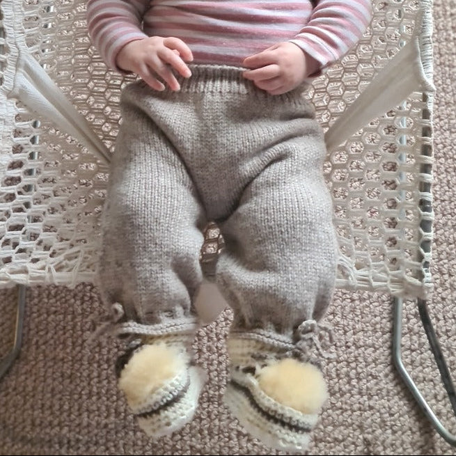 Baby wearing merino classic knit pants in oatmeal.