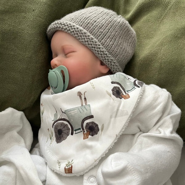 Baby wearing mushroom beanie and ryker dribble bib