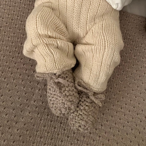 Baby wearing oatmeal chunky knit booties