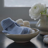 Blue and Ivory baby socks in a dish