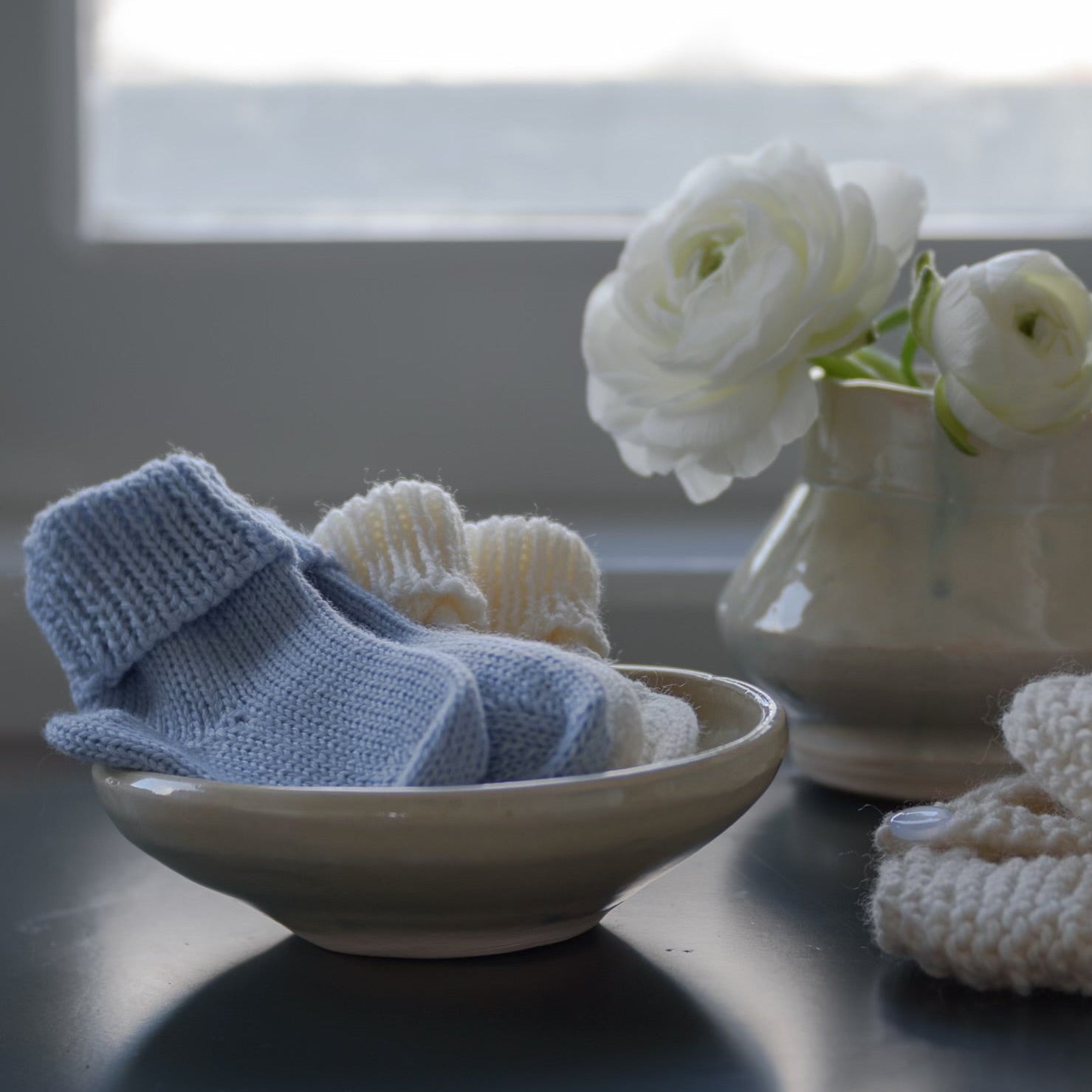 Blue and Ivory baby socks in a dish