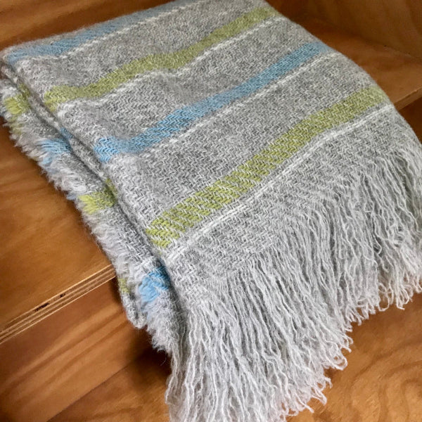 Striped blanket with fringes on a wooden surface
