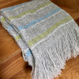 Striped blanket with fringes on a wooden surface